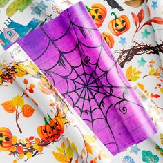 halloween wrapping paper with pumpkins, bats and spider web on it in various colors