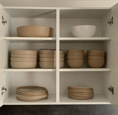 shelves with bowls and plates on them in a kitchen