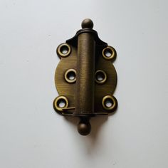 a close up of a door handle on a white wall with holes in the middle