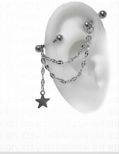 an ear with chains and balls attached to the side of it, as if they were chained