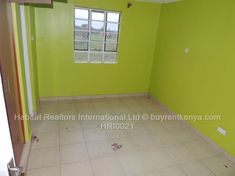 an empty room with green walls and tile flooring