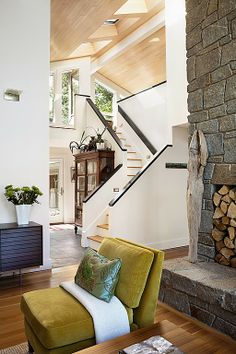 a living room filled with furniture and a fire place in front of a stair case