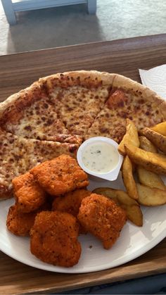 a pizza and some french fries on a plate with a side of dipping sauces