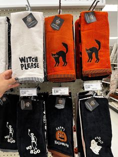 towels are on display in a store with halloween stickers hanging from the rack and black and white designs