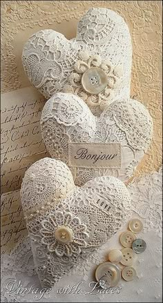 two white hearts with lace and buttons on them