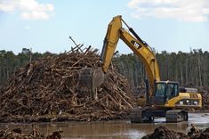 a bulldozer digging through a pile of wood