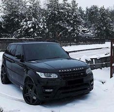 a black range rover is parked in the snow