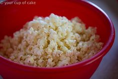 a red bowl filled with rice on top of a table