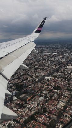 the wing of an airplane flying over a city