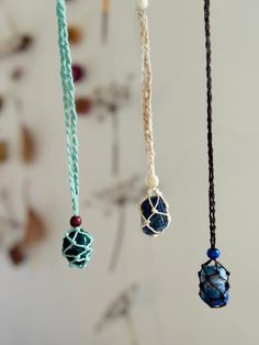 three necklaces hanging from the ceiling with beads