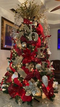 a christmas tree decorated with red and silver ribbon, ornaments and numbers on it's base