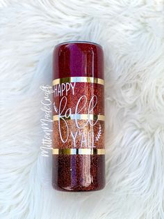 a red and gold glitter tumbler with the words happy fall on it