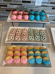 three tiered trays filled with different types of donuts and strawberries on top of each other