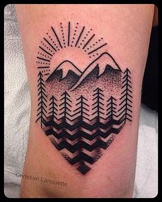 a tattoo with mountains and trees on it