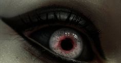 an evil looking woman's eye with blood on the inside of her irise