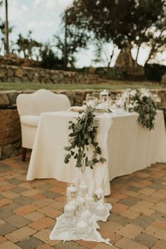 the table is set with candles and greenery