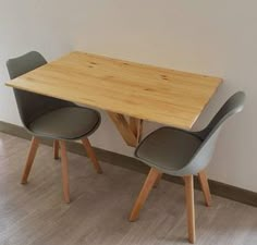 a wooden table with two chairs next to it