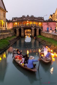 people are riding in small boats down the river at dusk with lanterns lit on them