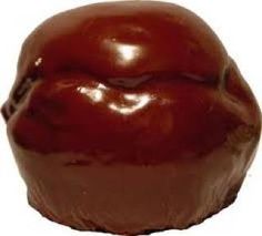 a chocolate covered donut sitting on top of a white surface