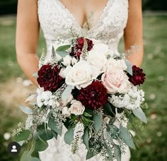 a bride holding a bouquet of red and white flowers