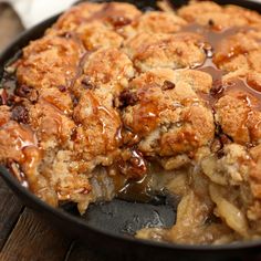 a skillet filled with apple cobbler and caramel drizzled on top