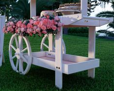 a cart with flowers on it sitting in the grass