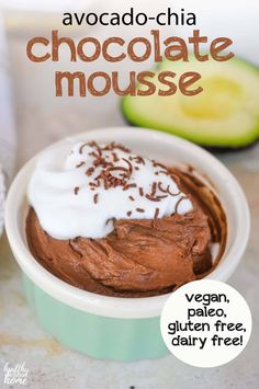 chocolate mousse in a bowl with whipped cream and sliced avocado on the side