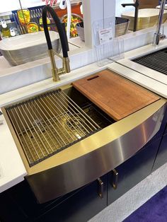 a kitchen sink with a cutting board on the bottom and an oven in the back