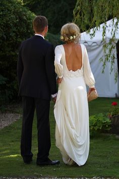 a bride and groom standing in front of a tent