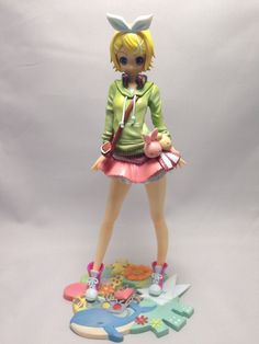 a figurine is posed on top of a table with various items around it