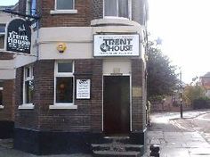 an old brick building on the corner of a street with signs for restaurant and other businesses