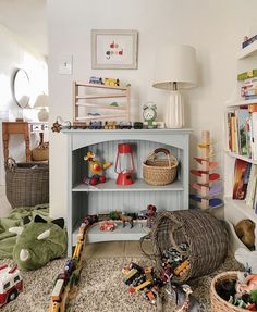 a child's room with toys on the floor and bookshelf in the corner