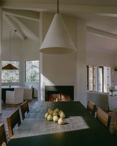 a dining room table with apples on it and a fire place in the middle of the room