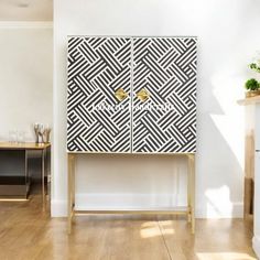 a white and black cabinet sitting on top of a hard wood floor