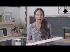 a woman standing in an office holding a piece of paper