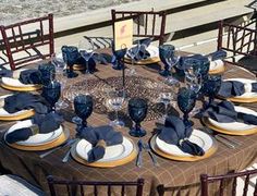 the table is set with blue and white plates, silverware, and napkins