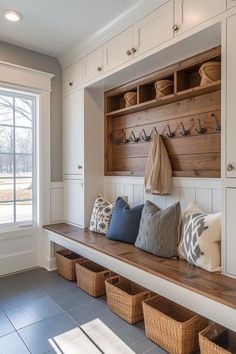 a wooden bench sitting under a window next to a bunch of baskets on top of it