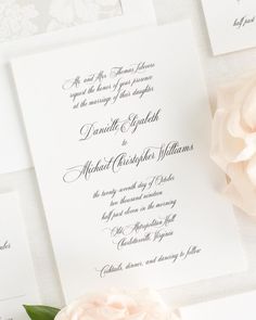 the wedding stationery is laid out on top of each other, with a pink flower