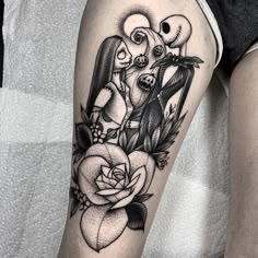 a woman's thigh with flowers and skulls on her legs, in black and white