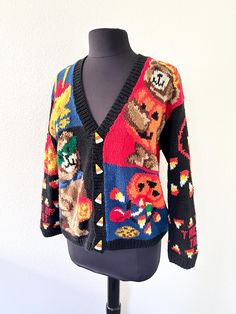 Freaking incredible vintage Halloween sweater from the 1990's! This thick and cozy knit sweater is decorated with trick-or-treating bears, pumpkin buckets spilling out candy, caramel apples, and candy corn buttons! The sleeves have jack-o-lantern pumpkins with candy corn and the words "trick or treat". The back has a big candy bucket with caramel apples, chocolate bars, lollipops, and candy corn. This is THE quintessential granny Halloween sweater. Colors are bright and vivid and sweater is in excellent condition. tagged Hand knit Alexandra Bartlett for the eagle's eye 55% ramie, 45% cotton tagged size petite MEDIUM, will fit up to LARGE bust 23" length 26" For reference, this is shown modeled on a dress form which measures 38", 27", 38" Find lots more rad vintage clothing of ALL sizes on Retro Hand Knitted Cardigan For Fall, Hand Knitted Retro Cardigan For Fall, Vintage Orange Sweater For Fall, Retro Hand-knitted Cardigan For Fall, Halloween Crochet Cardigan, Alternative Long Sleeve Halloween Sweater, Casual Halloween Knit Sweater, Vintage Halloween Sweater, Cotton Long Sleeve Halloween Sweater