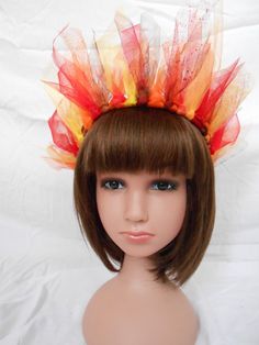 a mannequin headdress with orange and red feathers on it's head