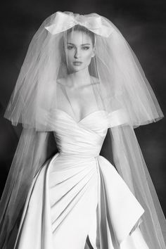 a black and white photo of a woman in a wedding dress with a veil on her head