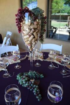 a table with wine glasses and grapes on it