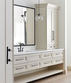 a white bathroom with two sinks and large mirrors