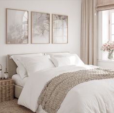 a bedroom with two paintings above the bed