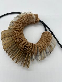 a bracelet made out of old book pages with leather cord attached to the clasps