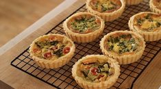 nine small quiche pies on a cooling rack