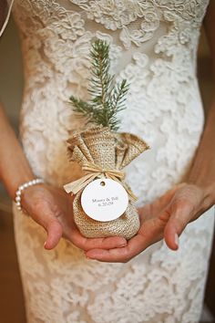 a person holding a small bag with a pine tree in it's palm and label