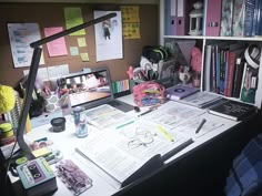 the desk is cluttered with books, papers and other things to do on it