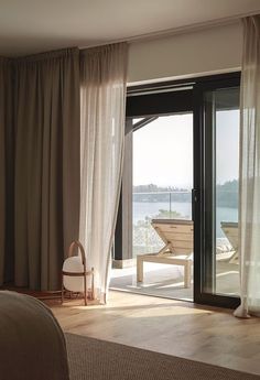 a bedroom with sliding glass doors leading out to the water